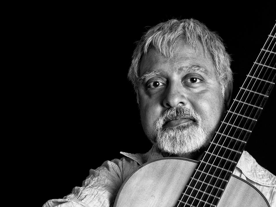 Image of Fareed Haque holding an acoustic guitar.